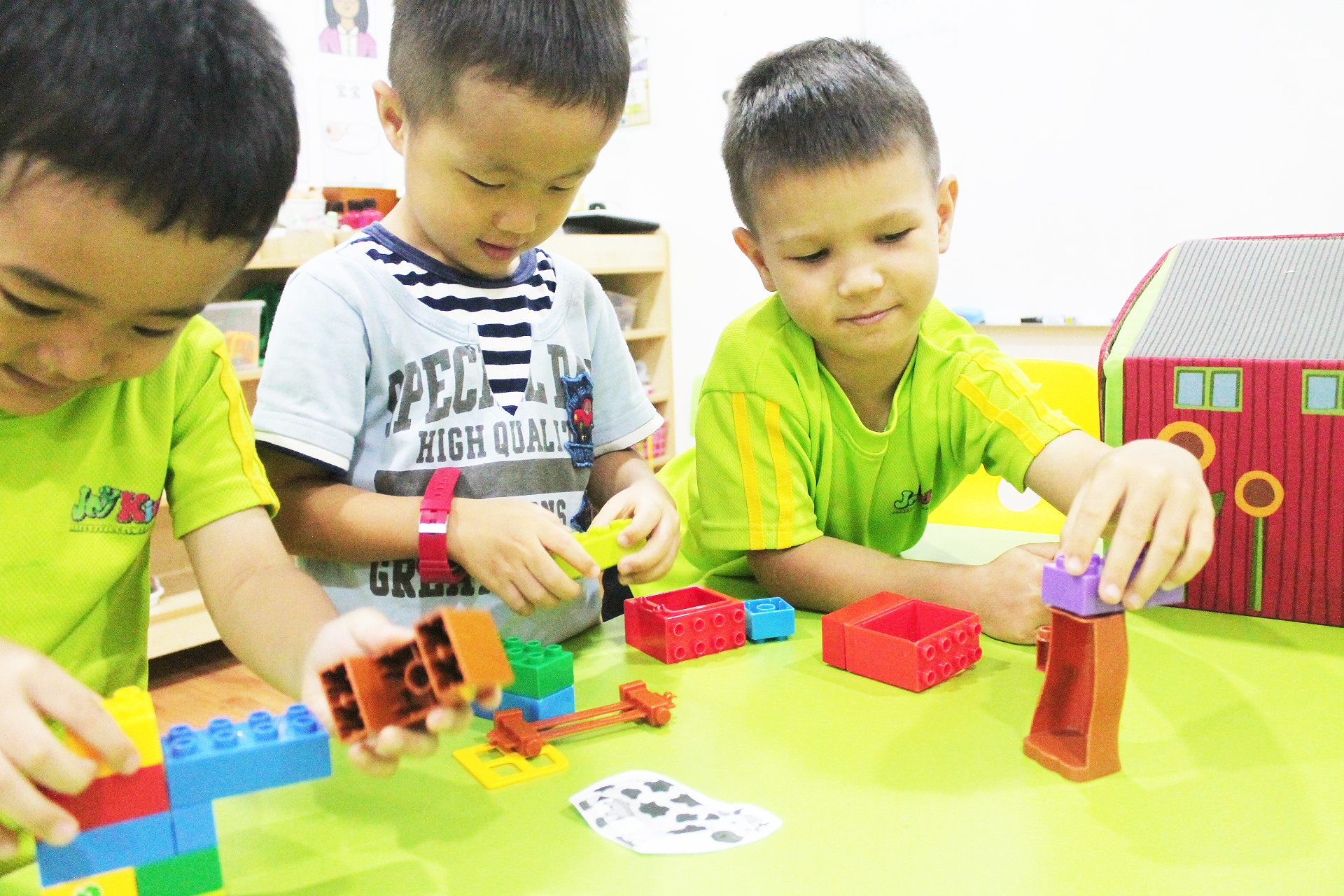 Preschool boys building with construction blocks in class at JoyKids International Preschool