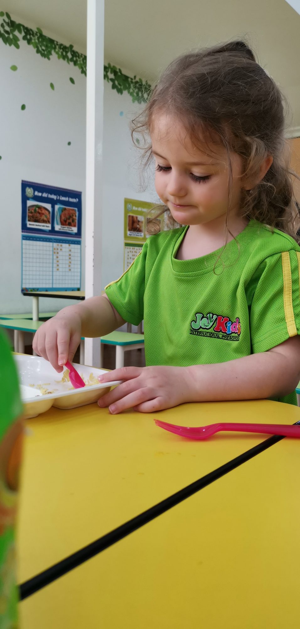 Preschool girl eating a healthy school lunch at JoyKids International Preschool, Bandar Utama